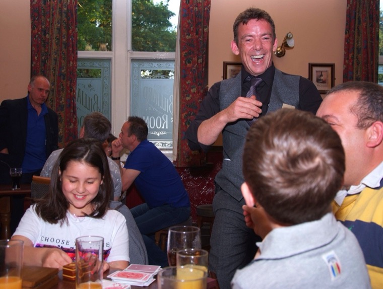 John entertaining a table of guests